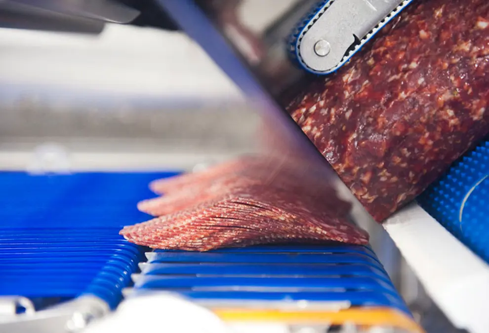 Factory machine slices processed pork