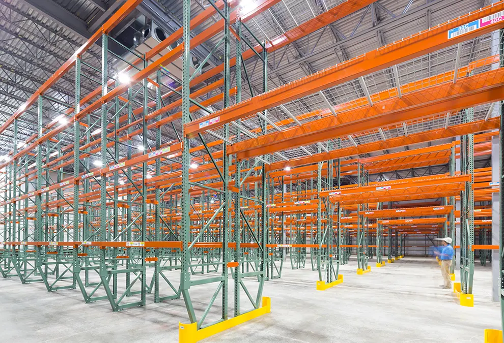 An empty warehouse with a single employee in the distance