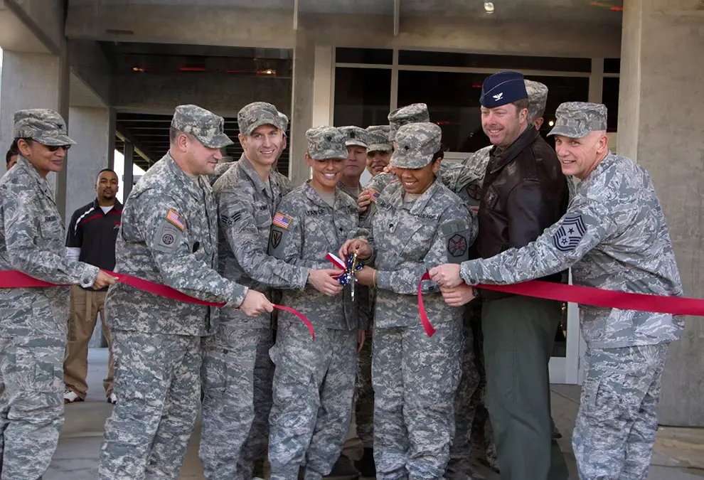 Uniformed military members cut a ceremonial ribbon.